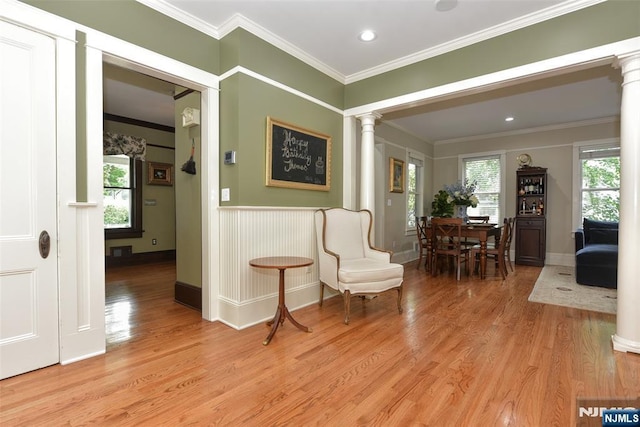  - living area featuring ornate columns, light wood-style flooring, crown molding, and recessed lighting