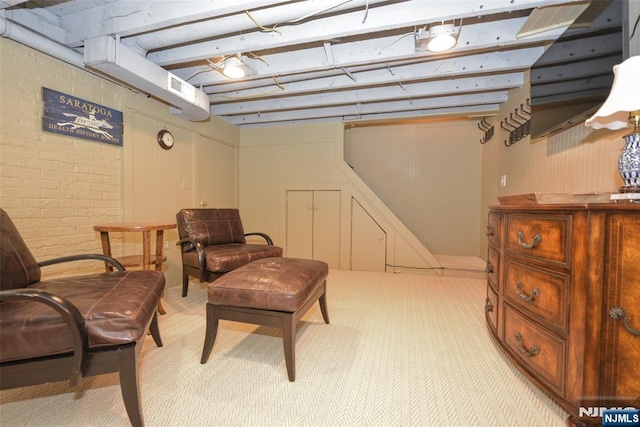  - living area with light carpet and brick wall