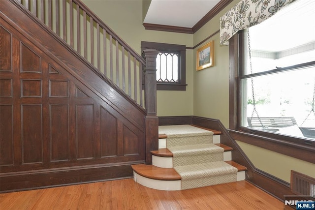  - stairway featuring wood finished floors and ornamental molding