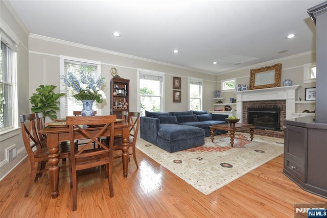  - dining area with light wood-type flooring, crown molding, a fireplace, and recessed lighting
