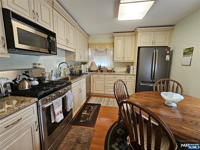 37 Pocohontas Path, Lincoln Park Borough, NJ 07035 - kitchen with appliances with stainless steel finishes, cream cabinetry, a sink, light wood finished floors, and light stone counters