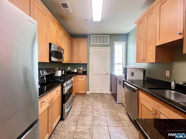 200 Dey St Unit 283, Harrison, NJ 07029 - kitchen featuring appliances with stainless steel finishes, light brown cabinetry, and dark stone counters
