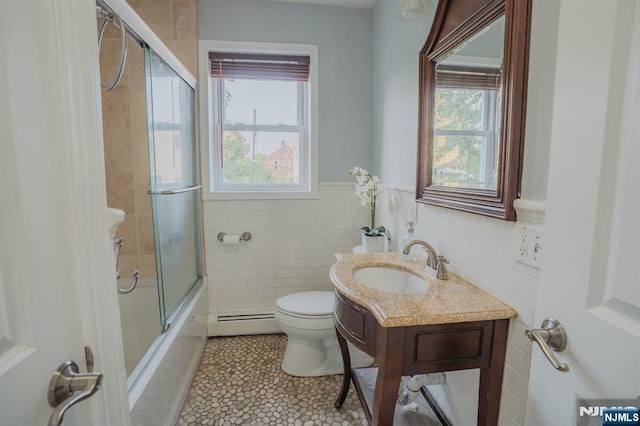 42 Berton Pl, Nutley, NJ 07110 - bathroom featuring baseboard heating, toilet, vanity, shower / bath combination with glass door, and tile walls