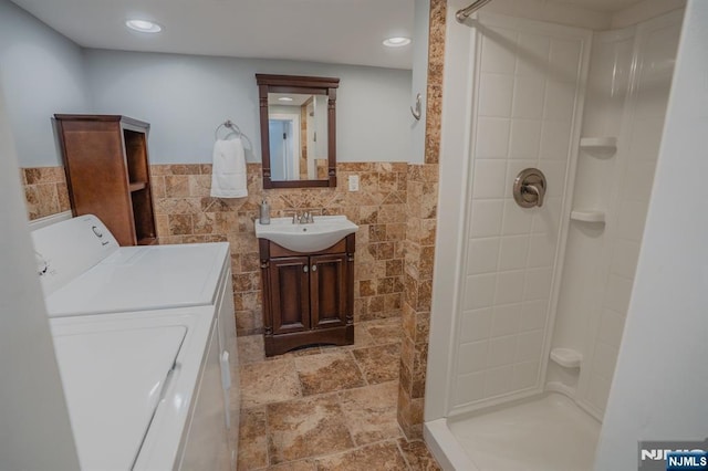 42 Berton Pl, Nutley, NJ 07110 - bathroom featuring tile walls, a shower, vanity, washer and dryer, and a wainscoted wall