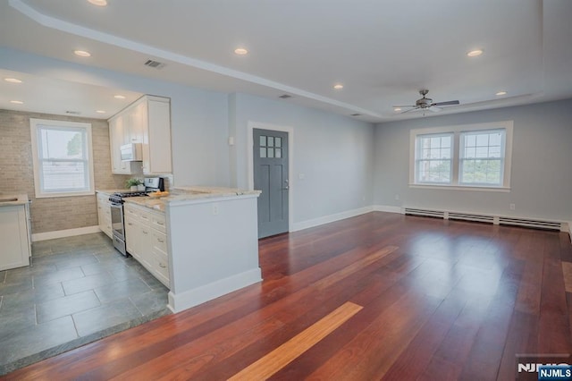 42 Berton Pl, Nutley, NJ 07110 - kitchen with stainless steel gas range, healthy amount of natural light, white microwave, light stone countertops, and recessed lighting