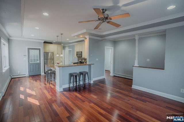 42 Berton Pl, Nutley, NJ 07110 - kitchen featuring stainless steel appliances, baseboard heating, cream cabinetry, a kitchen bar, and stone counters