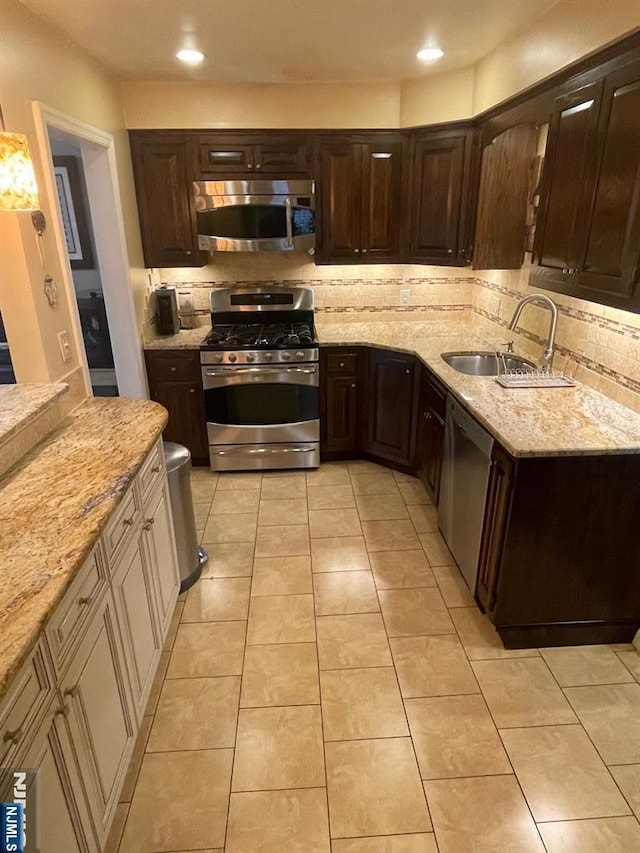 771 Stelton St, Teaneck, NJ 07666 - kitchen featuring stainless steel appliances, backsplash, dark brown cabinets, light stone counters, and light tile patterned floors