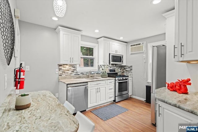 82 Elston St, Bloomfield, NJ 07003 - kitchen with appliances with stainless steel finishes, a sink, white cabinetry, a wall mounted AC, and recessed lighting