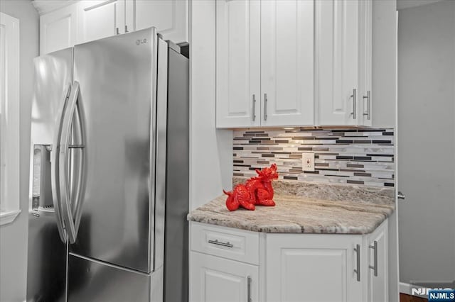 82 Elston St, Bloomfield, NJ 07003 - kitchen with stainless steel refrigerator with ice dispenser, tasteful backsplash, white cabinets, and light stone counters