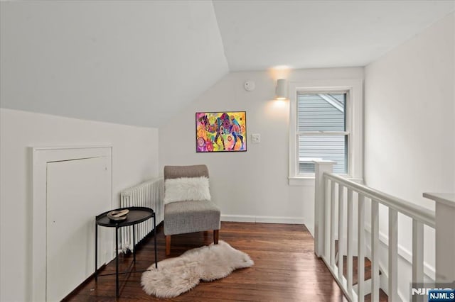 82 Elston St, Bloomfield, NJ 07003 - living area with wood finished floors, lofted ceiling, radiator heating unit, baseboards, and an upstairs landing