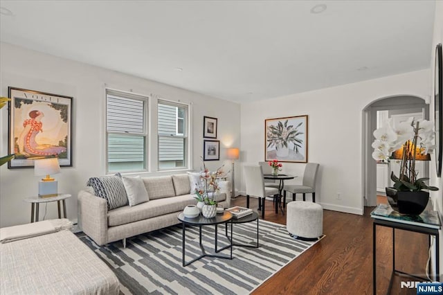 82 Elston St, Bloomfield, NJ 07003 - living room with dark wood-type flooring, arched walkways, and baseboards
