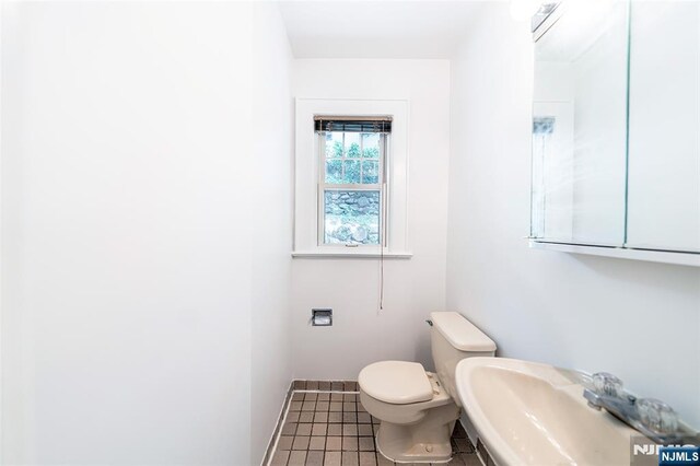 85 Paulin Blvd, Leonia, NJ 07605 - half bathroom with toilet, a sink, tile patterned floors, and baseboards