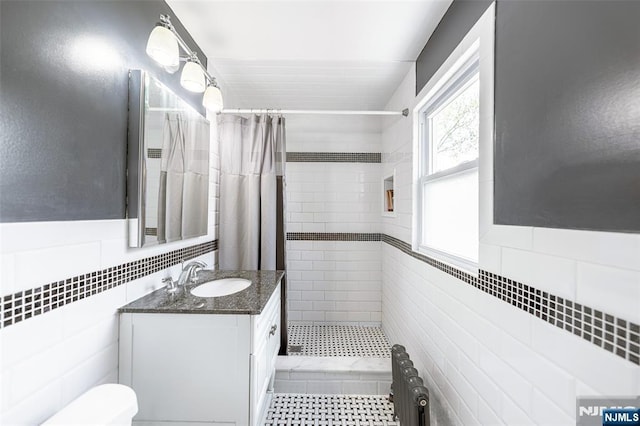 85 Paulin Blvd, Leonia, NJ 07605 - bathroom with tile walls, vanity, tiled shower, toilet, and radiator heating unit