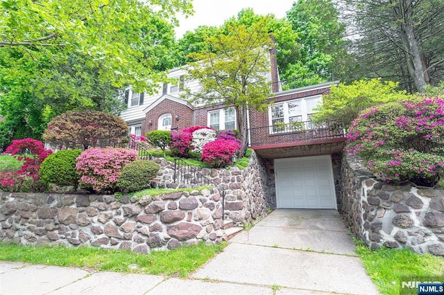 85 Paulin Blvd, Leonia, NJ 07605 - view of front of house featuring driveway, a garage, a balcony, stone siding, and a chimney