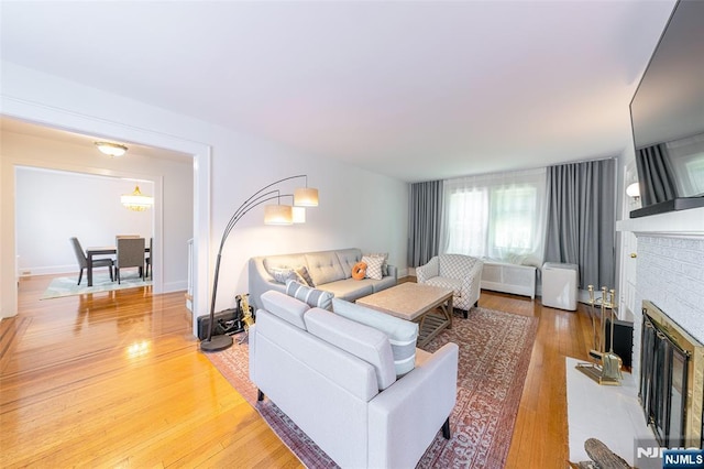 85 Paulin Blvd, Leonia, NJ 07605 - living room with light wood-style flooring, a brick fireplace, and radiator heating unit