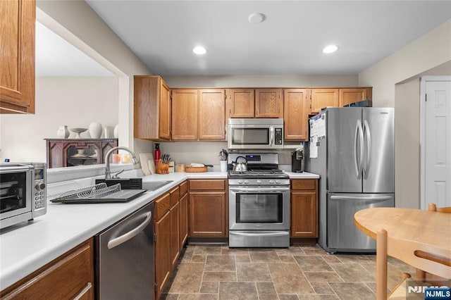 35 Spruce Ct Unit 116, Clifton, NJ 07014 - kitchen with stainless steel appliances, light countertops, stone finish floors, brown cabinets, and recessed lighting