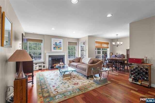 35 Spruce Ct Unit 116, Clifton, NJ 07014 - living room with healthy amount of natural light, a chandelier, wood finished floors, a fireplace with flush hearth, and recessed lighting