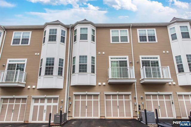 129 Eisenhower Ln Unit 2109, Wood Ridge, NJ 07075 - rear view of property with a garage, driveway, and cooling unit