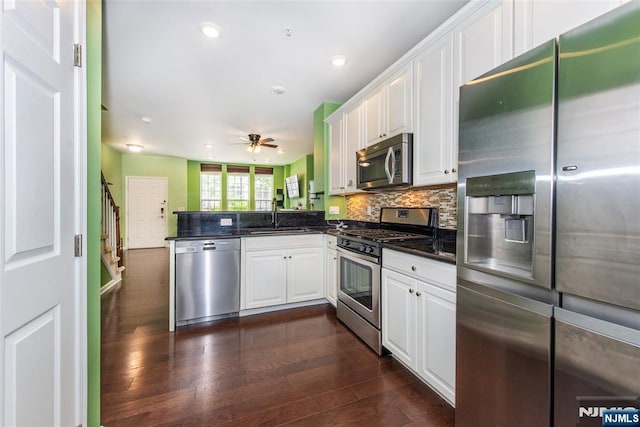 129 Eisenhower Ln Unit 2109, Wood Ridge, NJ 07075 - kitchen featuring stainless steel appliances, a sink, a peninsula, dark wood-style floors, and white cabinets