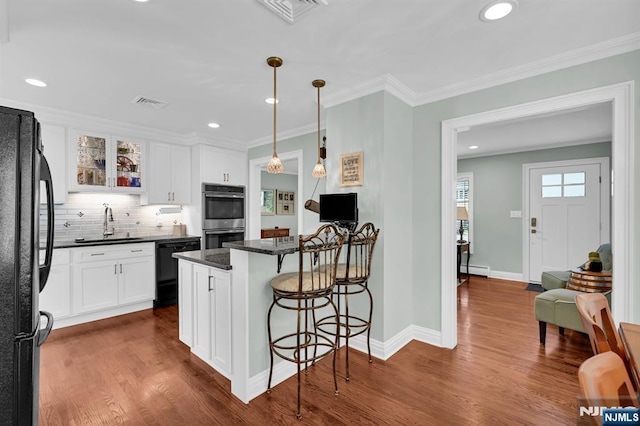 39 N 5th St, Park Ridge, NJ 07656 - kitchen featuring black appliances, a breakfast bar area, white cabinets, dark wood-style flooring, and recessed lighting