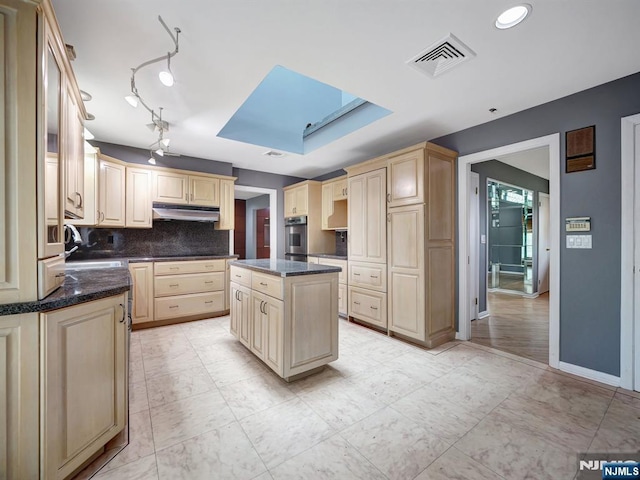 39 Daniels Dr, Clifton, NJ 07013 - kitchen with stainless steel oven, a sink, under cabinet range hood, a skylight, and decorative backsplash