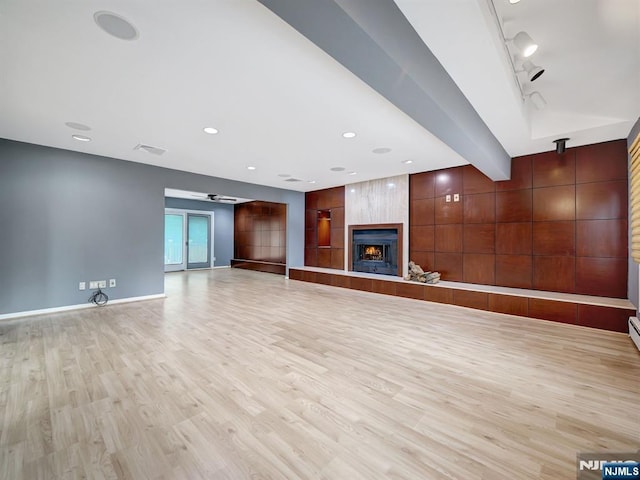 39 Daniels Dr, Clifton, NJ 07013 - unfurnished living room with light wood-type flooring, a large fireplace, rail lighting, and baseboards