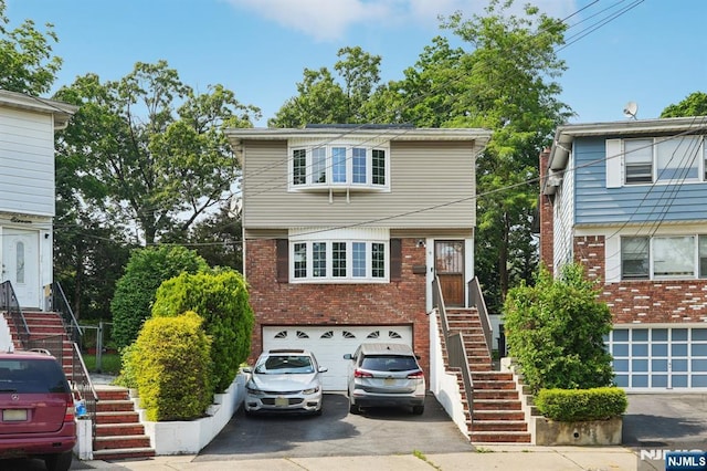 9 Lee Ct, Maplewood, NJ 07040 - view of front of house featuring stairway, driveway, a garage, and brick siding