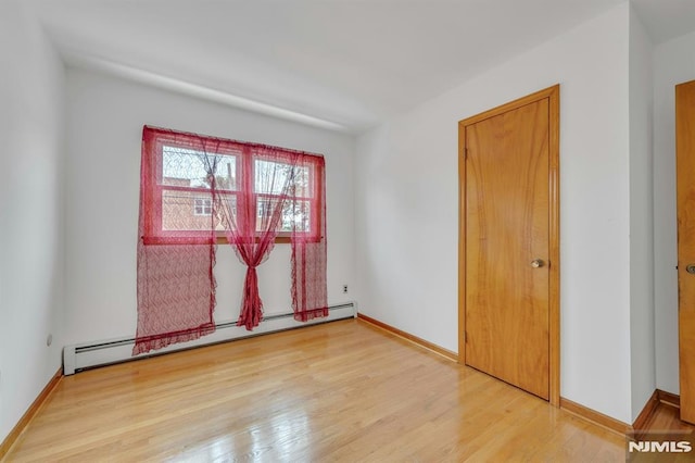 15 Jersey St, East Rutherford, NJ 07073 - empty room featuring a baseboard heating unit and light wood-style flooring