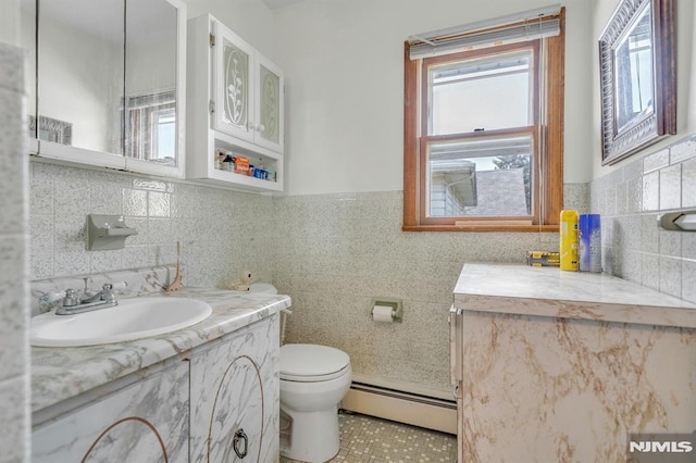 15 Jersey St, East Rutherford, NJ 07073 - bathroom with a baseboard radiator, vanity, tile walls, and tile patterned flooring