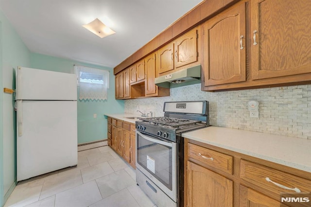 15 Jersey St, East Rutherford, NJ 07073 - kitchen featuring freestanding refrigerator, stainless steel gas range oven, under cabinet range hood, a baseboard radiator, and light countertops