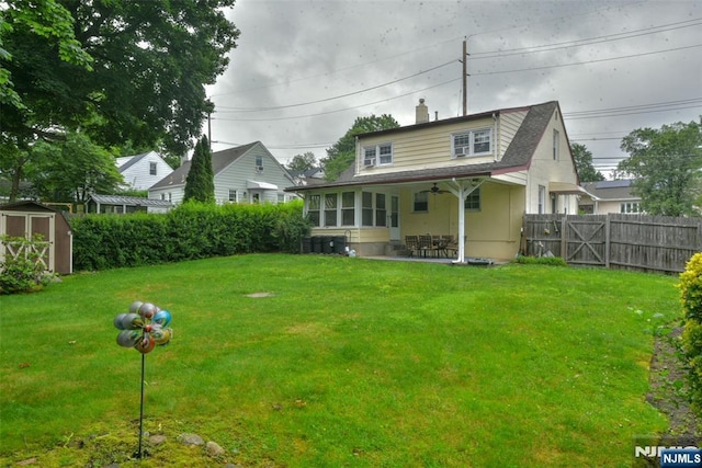 62 Overlook Ave, North Haledon, NJ 07508 - rear view of house with a storage unit, a fenced backyard, a patio, a ceiling fan, and a chimney