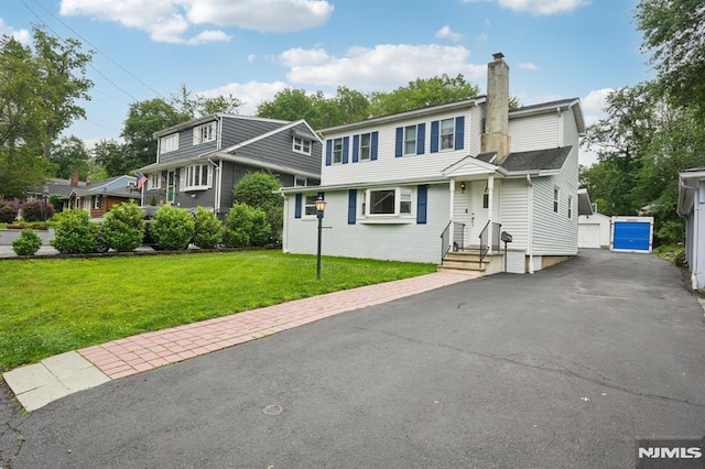4 Lenape Trl, Wayne, NJ 07470 - view of front of house with a chimney, a front yard, and an outbuilding