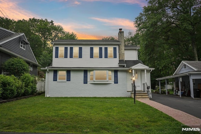 4 Lenape Trl, Wayne, NJ 07470 - view of front of house featuring a chimney, a front lawn, brick siding, and asphalt driveway