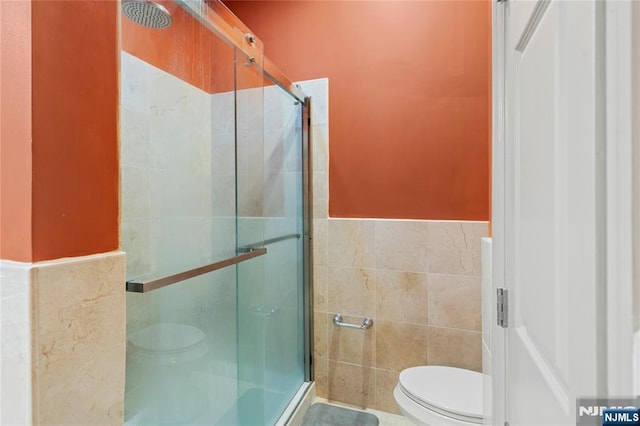 7400 River Rd Unit 120, North Bergen, NJ 07047 - full bath featuring a stall shower, tile walls, and wainscoting