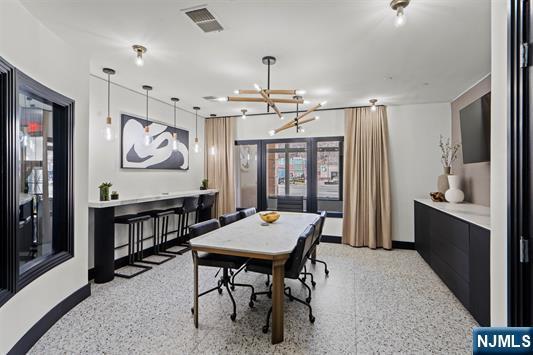 7400 River Rd Unit 120, North Bergen, NJ 07047 - dining area with dark speckled floor and a chandelier