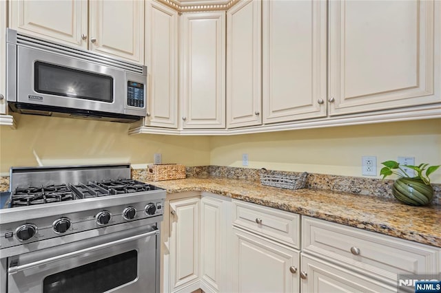 7400 River Rd Unit 120, North Bergen, NJ 07047 - kitchen featuring appliances with stainless steel finishes, light stone countertops, and white cabinets