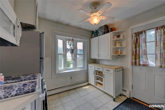 21 Bartholdi Ave, Wanaque, NJ 07420 - kitchen featuring open shelves, a baseboard radiator, stainless steel stove, white microwave, and healthy amount of natural light
