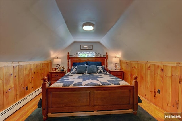 21 Bartholdi Ave, Wanaque, NJ 07420 - bedroom with a baseboard heating unit, wooden walls, wood finished floors, vaulted ceiling, and wainscoting