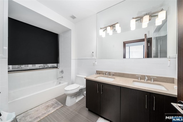 9 Somerset Ln Unit 201, Edgewater, NJ 07020 - bathroom featuring double vanity, a bathtub, wainscoting, and tile walls