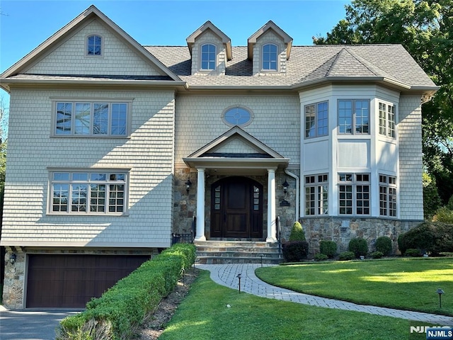 591 Warwick Ave, Teaneck, NJ 07666 - shingle-style home with stone siding, a front lawn, a garage, and driveway