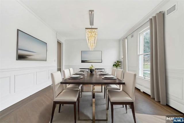 333 Mill Rd, Saddle River, NJ 07458 - dining area with a chandelier, crown molding, a decorative wall, wainscoting, and wood finished floors