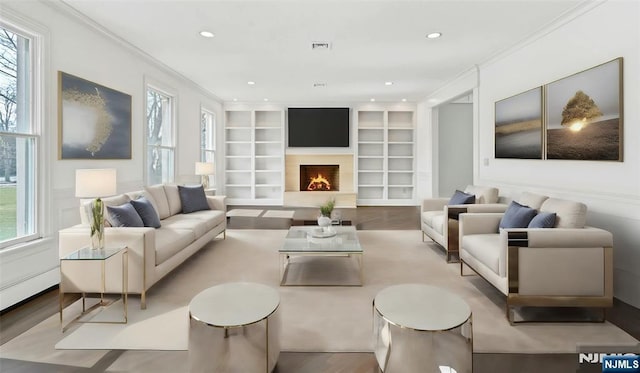 333 Mill Rd, Saddle River, NJ 07458 - living area with crown molding, wood finished floors, built in shelves, a lit fireplace, and recessed lighting
