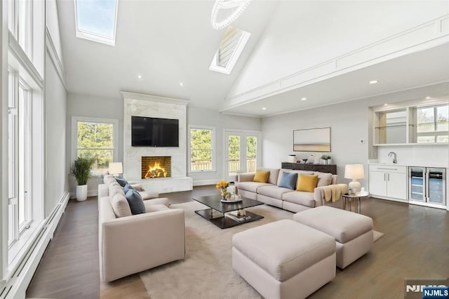 333 Mill Rd, Saddle River, NJ 07458 - living area with baseboard heating, high vaulted ceiling, a skylight, healthy amount of natural light, and wood finished floors