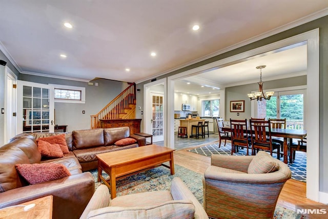 123 Buena Vista Ave, Hawthorne, NJ 07506 - living room with stairs, light wood-style flooring, ornamental molding, a chandelier, and healthy amount of natural light