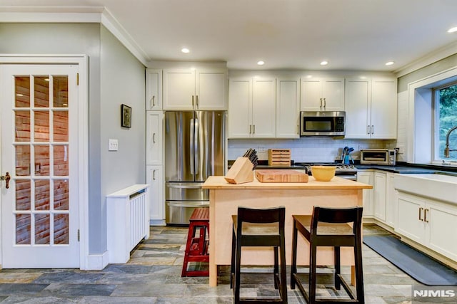 123 Buena Vista Ave, Hawthorne, NJ 07506 - kitchen with appliances with stainless steel finishes, decorative backsplash, recessed lighting, white cabinets, and a kitchen island