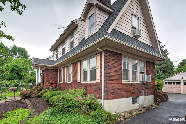 123 Buena Vista Ave, Hawthorne, NJ 07506 - view of side of property with brick siding, an outbuilding, cooling unit, a chimney, and a detached garage