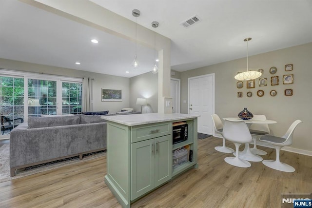 669 Juniper Way, Mahwah, NJ 07430 - kitchen with green cabinets, black microwave, light wood-type flooring, light countertops, and open floor plan