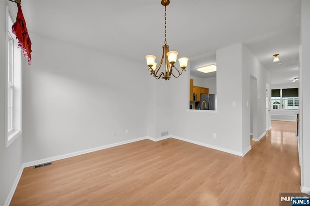 231 Swathmore Dr, Nutley, NJ 07110 - empty room with light wood finished floors and a chandelier
