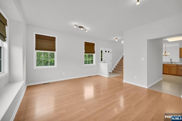 231 Swathmore Dr, Nutley, NJ 07110 - spare room with healthy amount of natural light, light wood-type flooring, a chandelier, and stairway
