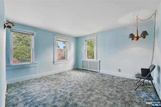 405 Abbott Ave, Ridgefield, NJ 07657 - carpeted empty room with radiator heating unit and plenty of natural light